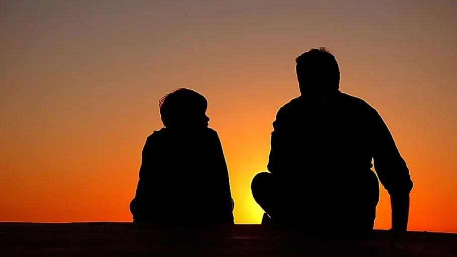 Father and child watching the sunset together